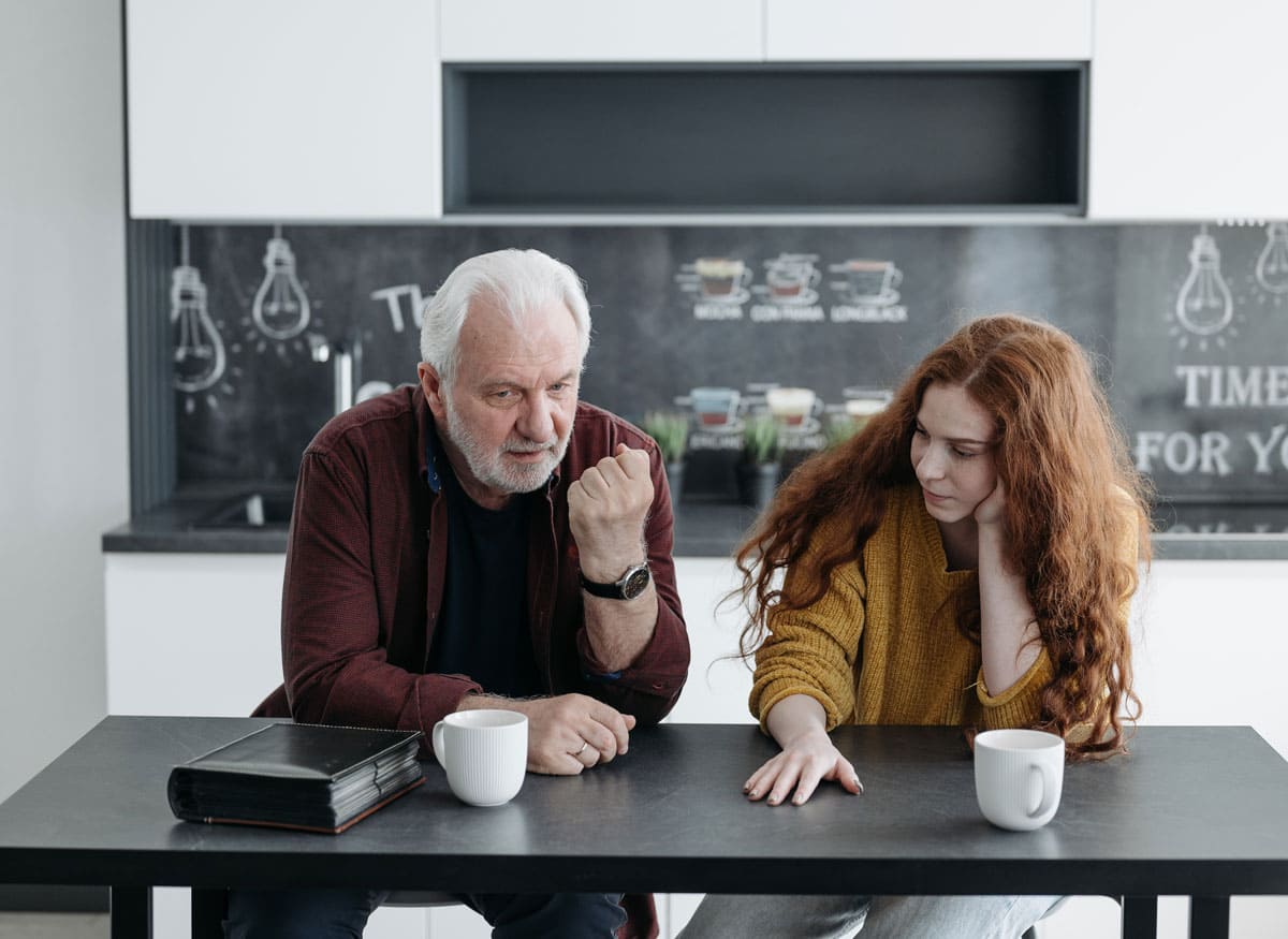 Un señor y una chica conversan mientras toman un café.